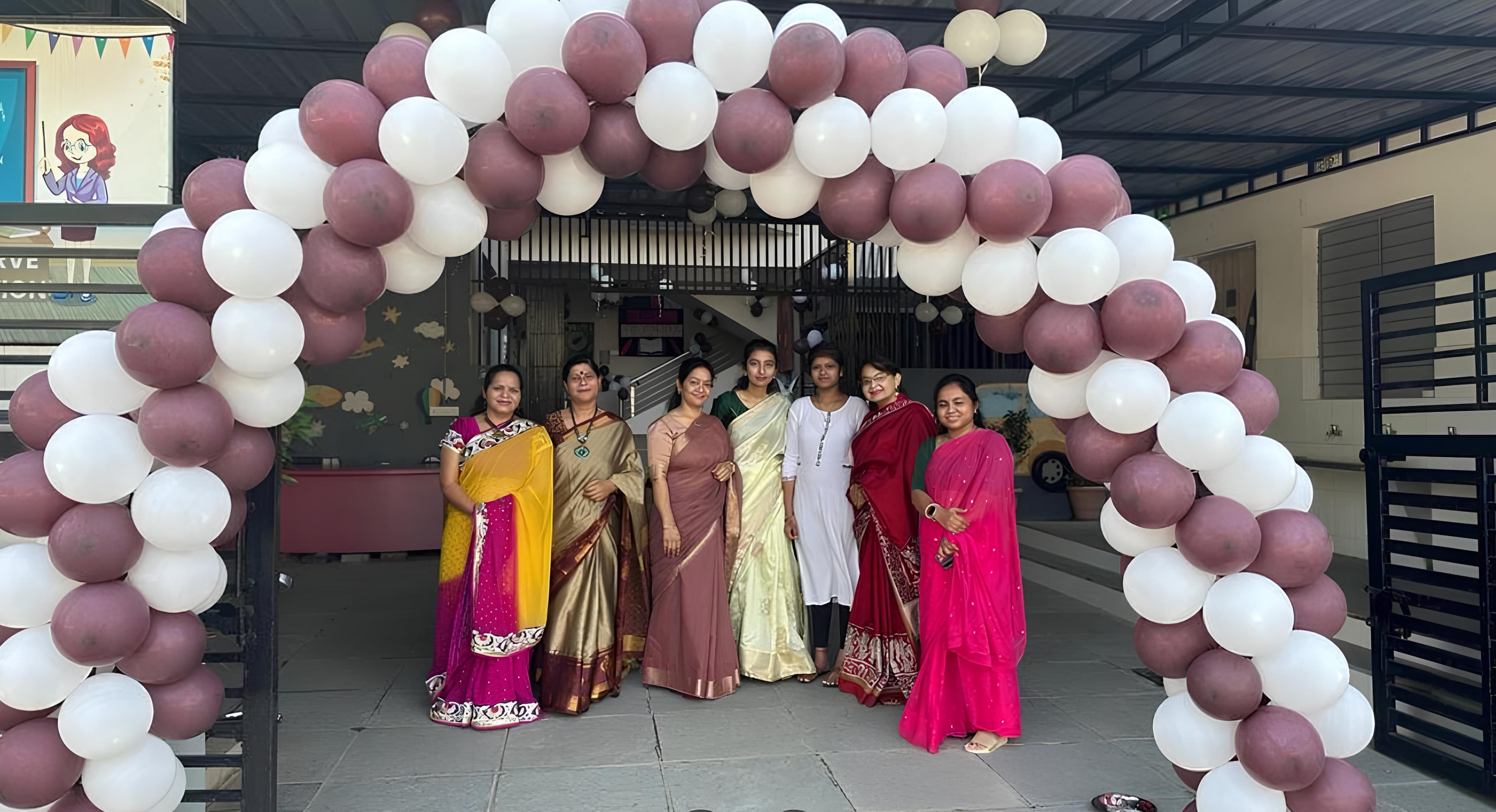 RC Kids staff standing under a balloon arch at the school entrance